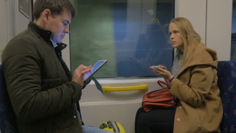 Family-Travels-In-A-Train-With-Digital-Tablets