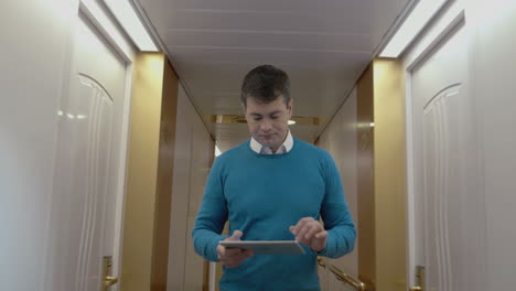 Man-working-with-pad-in-hotel-hallway