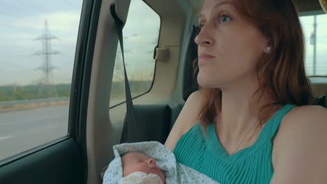 Young-Mother-Holding-Newborn-In-The-Car