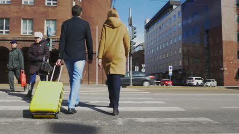 Man-and-woman-with-suitcase-crossing-the-road