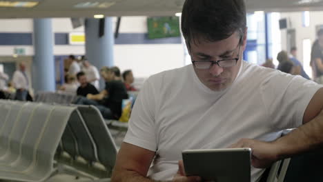 Junger-Mann-Arbeitet-Mit-Touchpad-Am-Flughafen