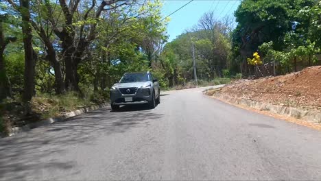 Híbrido-De-Serie,-Nissan-X-Trail-Conduciendo-En-La-Calle-Entre-árboles,-Suv-Crossover-Compacto