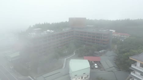 Establish-shot-flying-through-morning-mist-over-Hotel-indigo-in-Taiwan