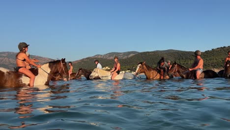 People-enjoy-riding-bareback-horses-in-seawater-during-summer-season