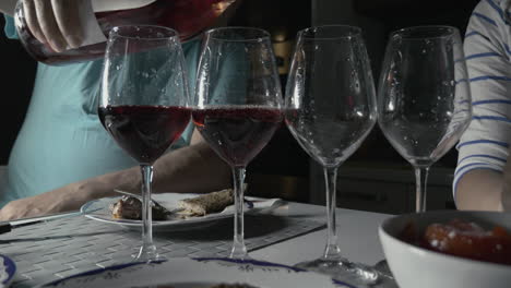 Mann-Gießt-Rotwein-In-Vier-Gläser