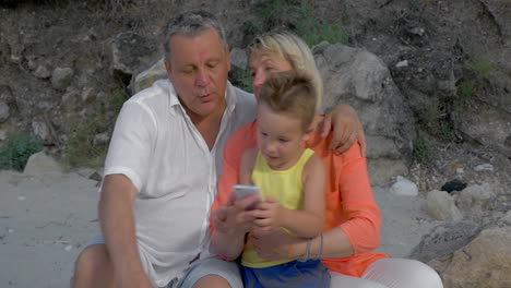 Boy-and-grandparents-looking-at-photos-on-smartphone