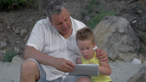 Enkel-Und-Großvater-Mit-Touchpad-Im-Freien