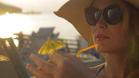 Mujer-Con-Sombrero-Y-Gafas-De-Sol-Bebiendo-Cóctel