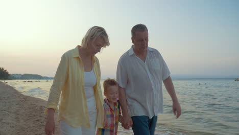 Grandparents-and-little-grandchild-walking-on-the-beach