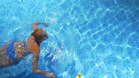 Frau-Schwimmt-An-Einem-Heißen,-Sonnigen-Tag-Im-Pool