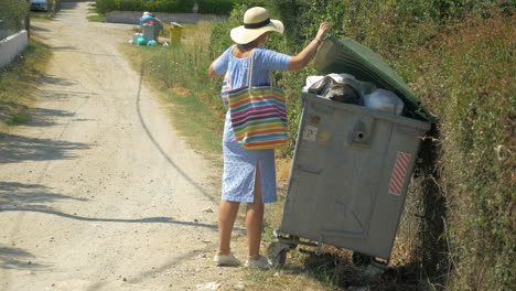 Frau-Bringt-Den-Müll-In-Den-Straßencontainer