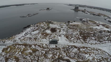 Aerial-view-of-car-driving-to-waterside-in-winter