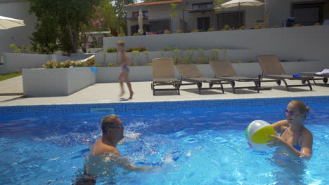 Mann-Und-Frau-Spielen-Ball-Im-Schwimmbad