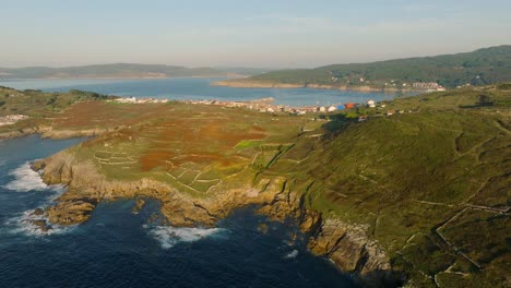 Aerial-View-Of-Rock-Fence-On-The-Mountain-Hills-Overlooking-The-Laxe-Town-And-Beach-In-Spain