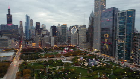 Aerial-pan-shot-of-illuminated-parks-and-the-skyline,-fall-evening-in-Chicago