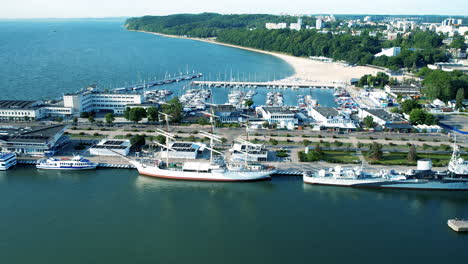 Aerial-view-of-parking-boats-and-ships-at-harbor-of-Gdynia-with-marina-and-coastline-during-sunny-day