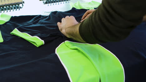 Männlicher-Arbeiter-überprüft-Das-Nähen-Von-Baumwoll-T-Shirts