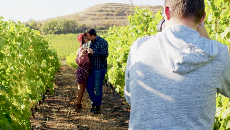 Caucasian-couple-being-photographed-in-a-vineyard