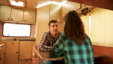 Caucasian-couple-having-a-conversation-in-their-retro-camper-van