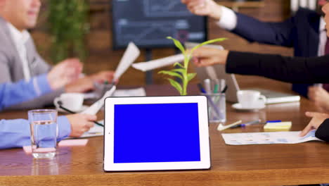 Tableta-Con-Pantalla-Azul-Sobre-La-Mesa-En-La-Sala-De-Conferencias
