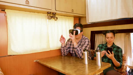 Young-man-with-vr-goggles-inside-of-retro-camper-van
