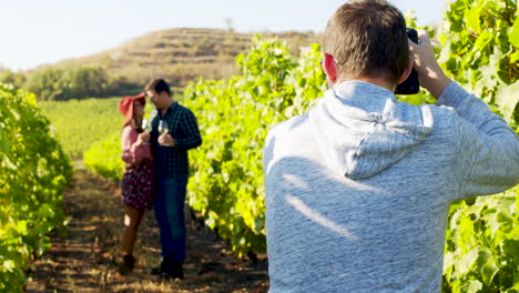 Photographer-taking-pictures-of-lovely-couple-in-a-vineyard