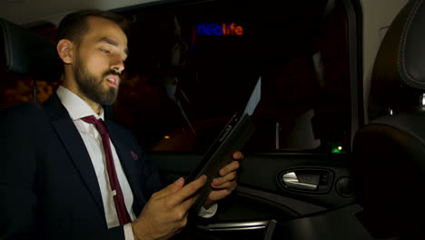 Businessman-during-a-business-video-call-in-the-back-seat-of-his-luxury-car
