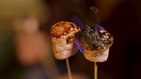 Close-up-of-delicious-marshmallow-on-sticks-roasting