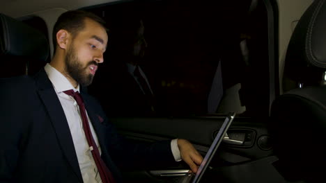 Businessman-looking-over-the-window-of-his-luxury-car-at-night