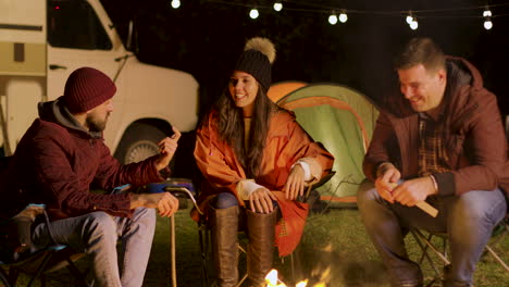 Group-of-close-friend-relaxing-together-around-camp-fire-in-a-cold-night-of-autumn