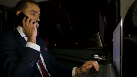 Bearded-businessman-yelling-during-a-phone-call-in-the-back-seat-of-his-limousine