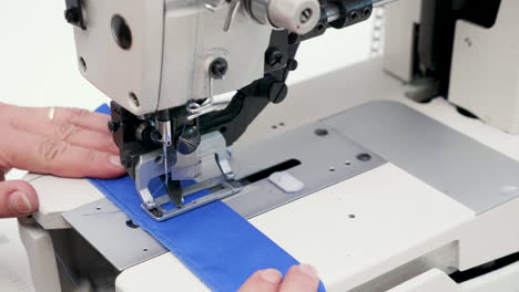 Female-worker-using-a-sewing-machine-to-cut-holes-for-buttons
