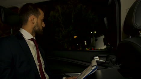 Businessman-at-night-in-the-back-seat-of-his-limousine