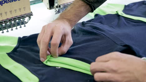 Close-up-of-man-hand-in-a-sewing-factory-checking-t-shirts
