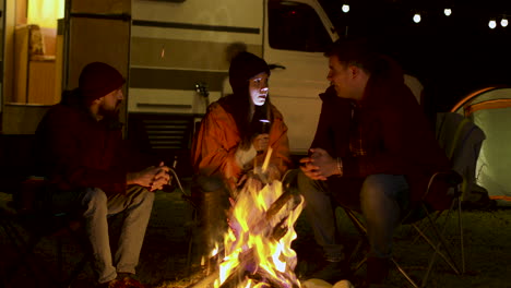 Girl-telling-a-scary-story-to-her-friends-around-camp-fire