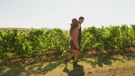 Couple-carrying-a-big-basket-with-white-grapes-in-a-beautiful-vineyard