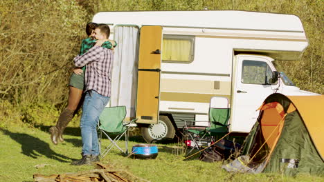 Boyfriend-spinning-around-her-girlfriend-in-front-of-their-retro-camper-van