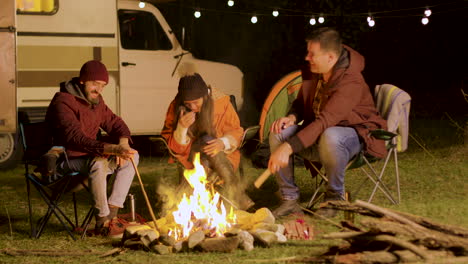 Bearded-man-telling-a-funny-joke-to-his-friends-around-camp-fire