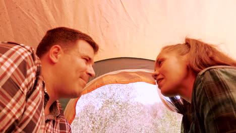 Inside-view-from-a-camping-tent-of-couple-smiling-at-each-other