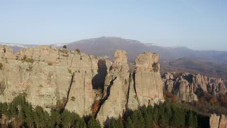 Panning-form-left-to-right-while-taking-an-aerial-drone-shot-of-the-Belogradchik-natural-rock-sculptures,-situated-west-of-the-town-of-Belogradchik,-in-the-foothills-of-the-Balkan-mountain-range