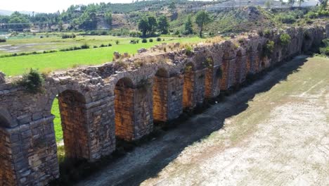 Slow-pan-of-Old-Aqueduct-shadow-side-during-sunny-day-in-Side,-Turkey