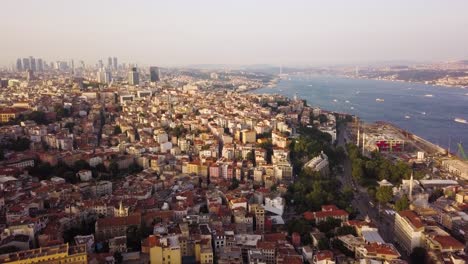Aerial-flying-over-Istanbul-city-at-golden-hour,-Bosphorus-Strait-on-right-side