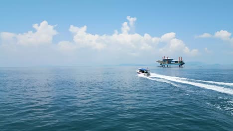 Aerial-orbiting-shot-of-a-small-celebes-sea-boat-heading-out-to-sea-with-divers