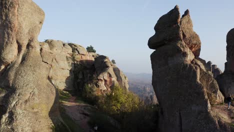 Fly-through-aerial-drone-shot-going-in-between-the-huge-natural-rock-formations-of-the-Belogradchik-clifffs,-located-in-the-province-of-Vidin-in-Bulgaria