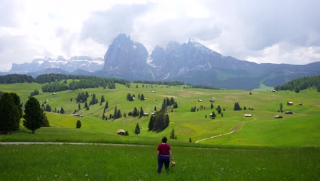 Caucasian-woman-smiles-openning-her-arms-and-admires-Alpe-di-Siusi-landscape,-Italy