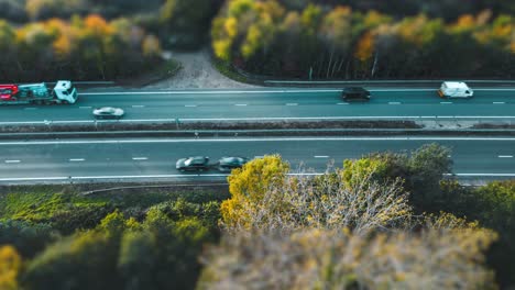Aerial-View-Of-Cars-Driving-On-The-Busy-Road-Between-The-Trees