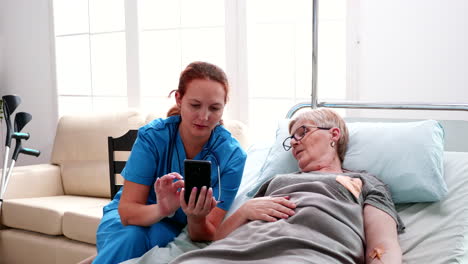 Enfermera-Ayudando-A-Una-Anciana-A-Usar-Un-Teléfono-Inteligente