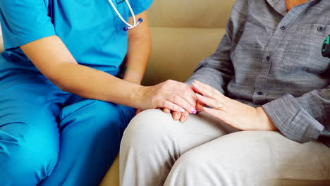Close-up-of-female-caretaker-in-nursing-home-holding-senior-woman-hand