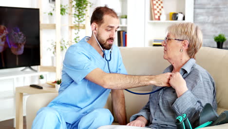 Caucasian-male-doctor-in-nursing-home-listening-old-woman-heartbeat