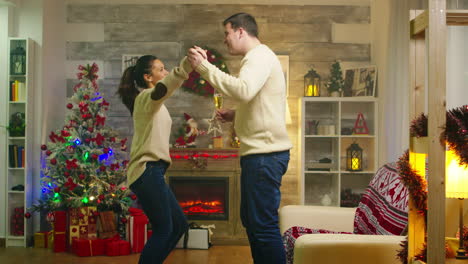 Cheerful-young-couple-dancing-in-living-room